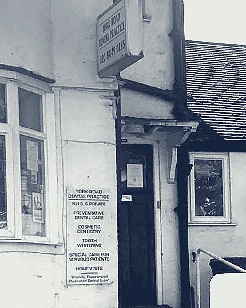 The practice doorway. The sign on the wall lists: NHS and private, preventative dental care, cosmetic dentistry, tooth whitening, special care for nervous patients, home visits.